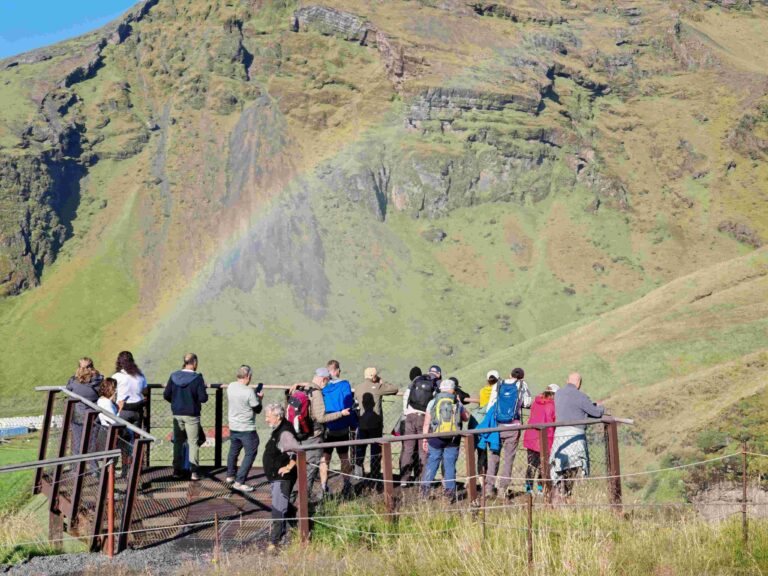 Travelers at Skógafoss Viewing Platform Iceland