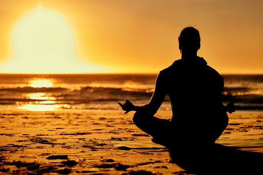 Person in a relaxed yoga pose at sunset in Maui, symbolizing mindfulness and reflection during the CGA Hawaiian Weekend Getaway