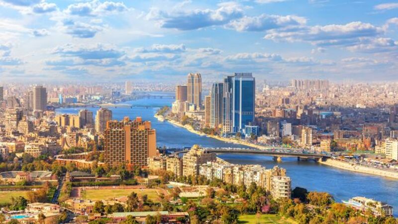 Panoramic view of the Cairo skyline with the Nile River and modern city buildings, representing the starting point of the Pride Adventures Egypt & the Nile LGBTQ+ group trip.