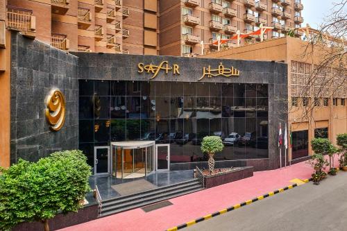 Main entrance of the 5-star Safir Hotel Cairo with palm trees and modern architecture.
