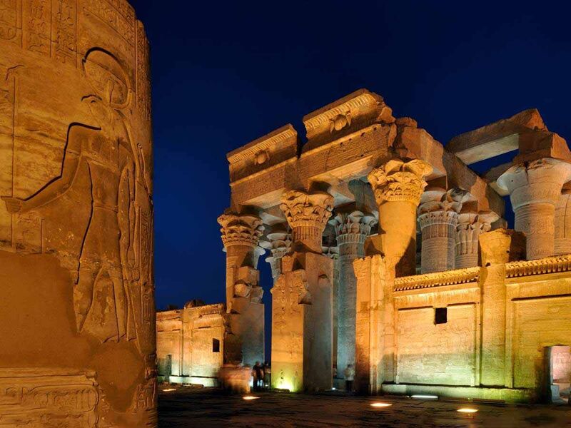 Kom Ombo Temple illuminated at dusk along the Nile River in Egypt.
