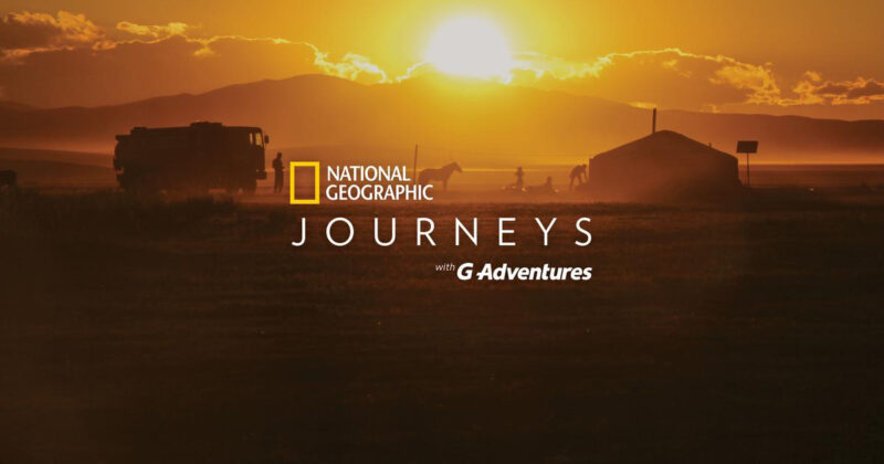 National Geographic Journeys desert scene with a horse standing beside a tent and an overland vehicle with National Geographic and G Adventures partnership branding