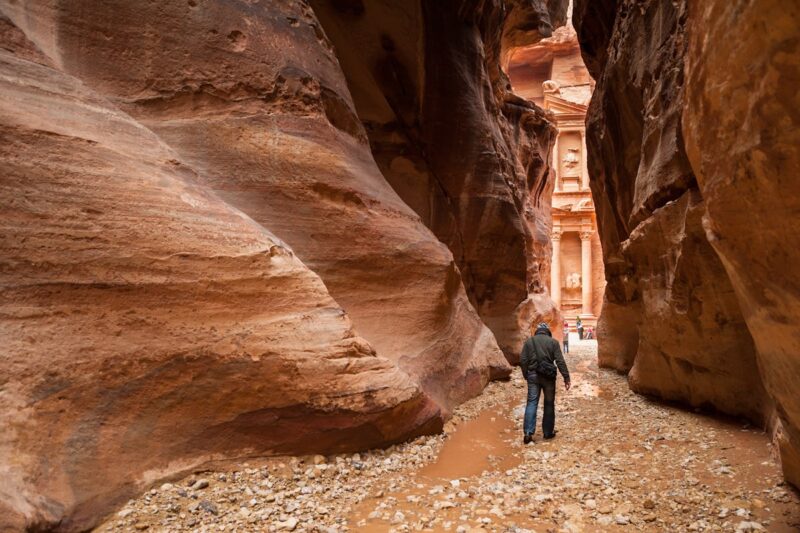 Walking through the narrow sandstone canyon of the Siq leading to the Treasury in Petra Jordan