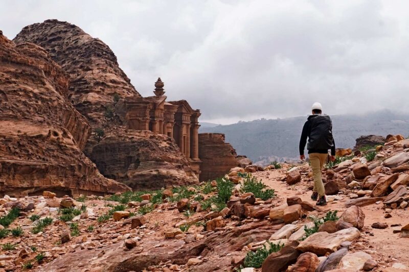 Travelers hiking through the red rock pathways of Petra with optional ridgeline and Treasury overlook routes available