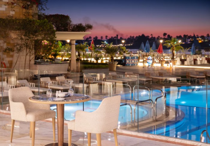 Evening view of the poolside restaurant at the 5-star Sonesta St. George Hotel Luxor overlooking the Nile River.