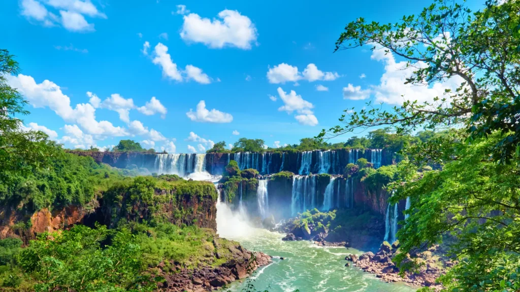 Panoramic view of Iguazu Falls on the border of Argentina and Brazil surrounded by lush rainforest