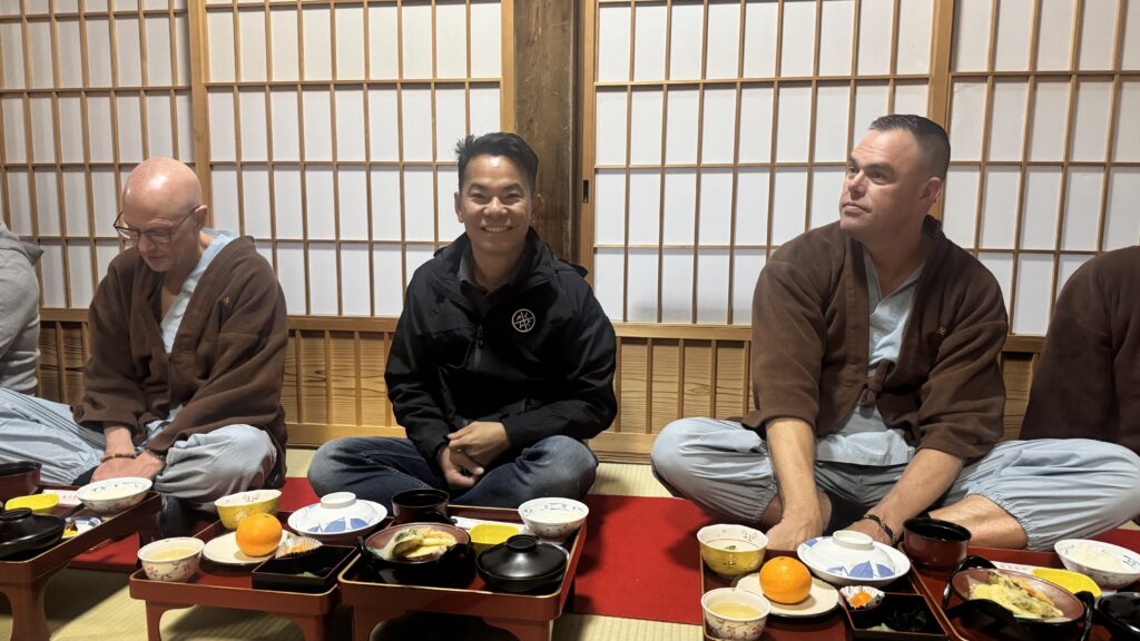 LGBTQ+ travel group seated inside a Buddhist temple in Koyasan Japan during overnight stay