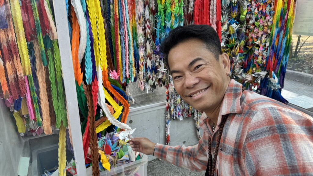 Traveler smiling in front of vibrant Tanabata paper decorations at a Japanese festival