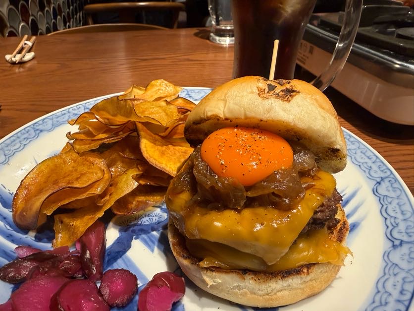 Japanese-style burger with fried egg and chips served on a plate in Japan
