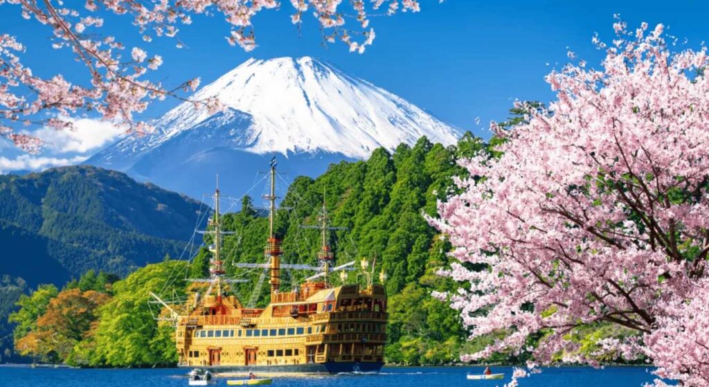 Lake Ashi in Hakone Japan with Mount Fuji and cherry blossoms reflecting on the water
