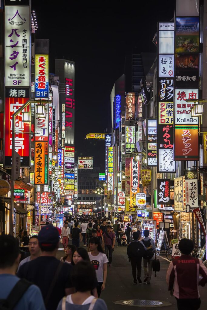 Colorful neon signs and glowing storefronts in Shibuya district of Tokyo Japan at night