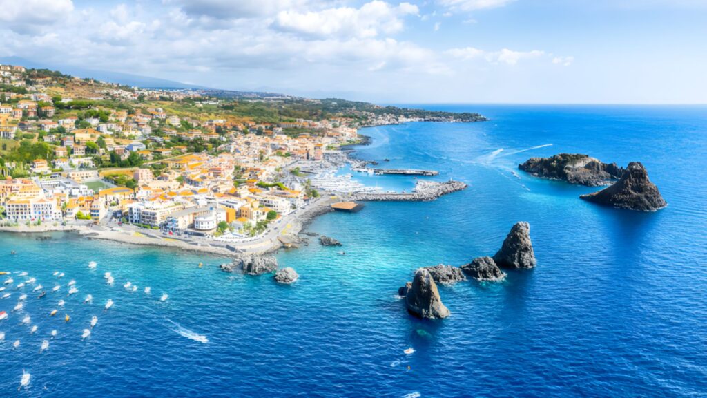 Aci Trezza coastline in eastern Sicily with Cyclops rock formations and turquoise sea