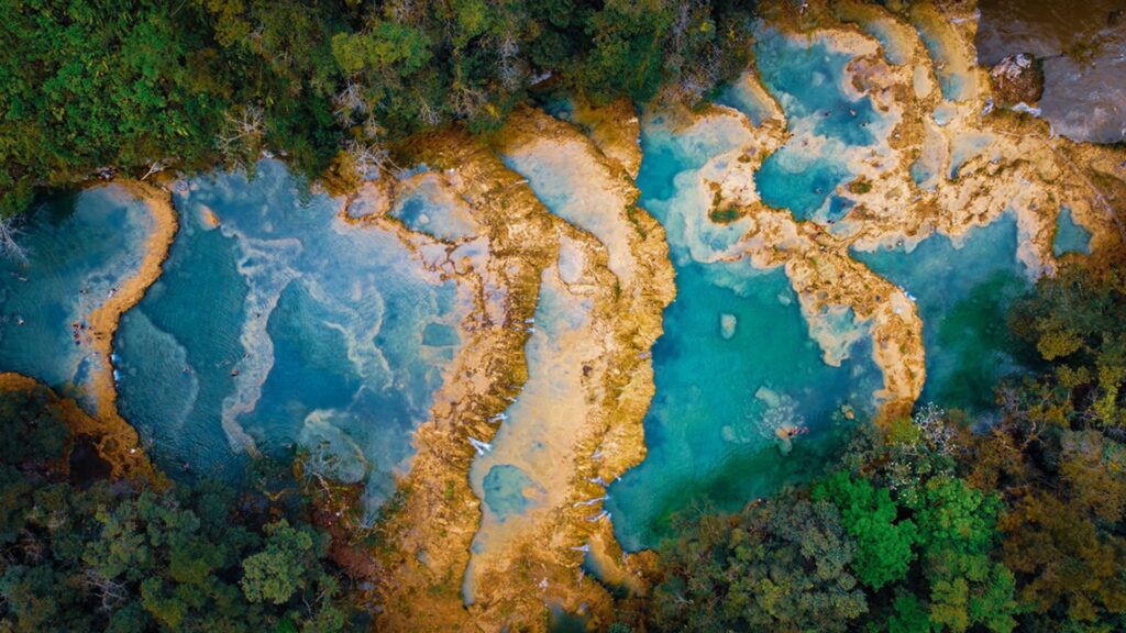 Aerial view of the turquoise natural pools and lush jungle canopy at Semuc Champey in Guatemala