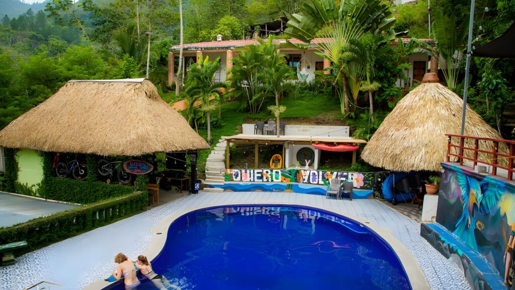 Travelers relaxing in a jungle pool at Hotel Vinas Lanquin surrounded by lush hills in Guatemala