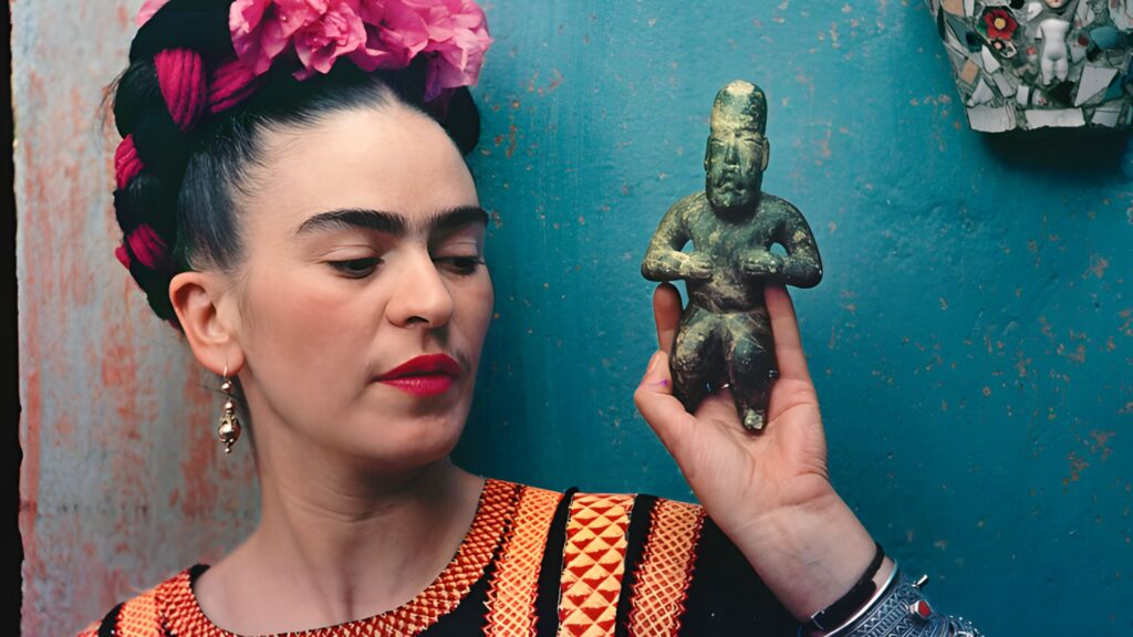 Person dressed in Frida Kahlo style with flower crown and traditional embroidered blouse holding a pre Columbian figurine in Mexico City