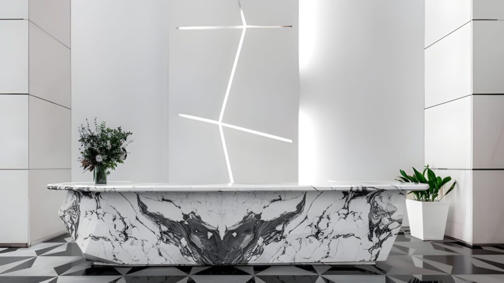 Dramatic Sofitel Mexico City hotel lobby with marble reception desk, geometric tiled floor, sculptural LED lighting, and floral arrangement