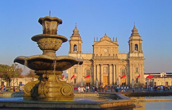 Historic Plaza Mayor fountain in Guatemala City with the Metropolitan Cathedral at golden hour
