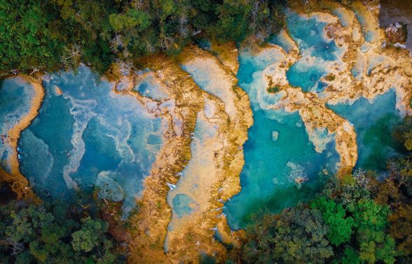 Aerial view of the turquoise natural pools and lush jungle canopy at Semuc Champey in Guatemala