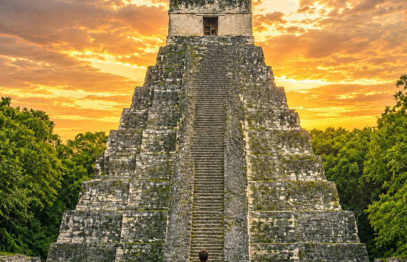 Ancient Maya temple rising above the jungle canopy at Tikal National Park in Guatemala at sunset